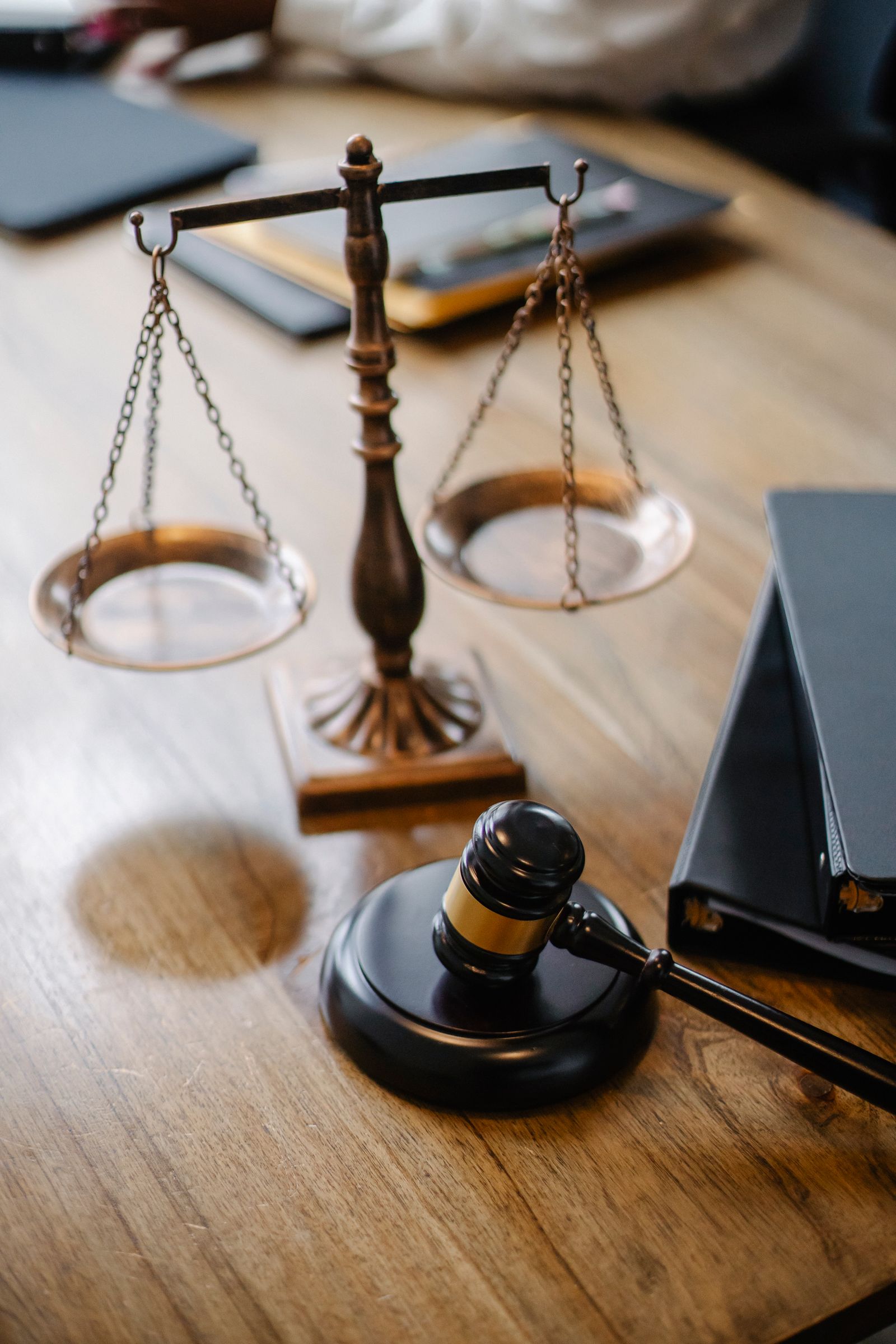 Balança da justiça e martelo sobre mesa de escritório jurídico